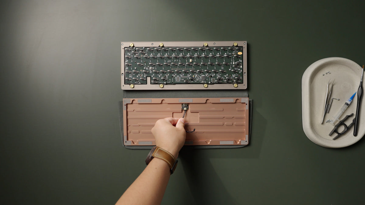 Hold the assembled daughterboard and cable by the cable to align it into the bottom recess.