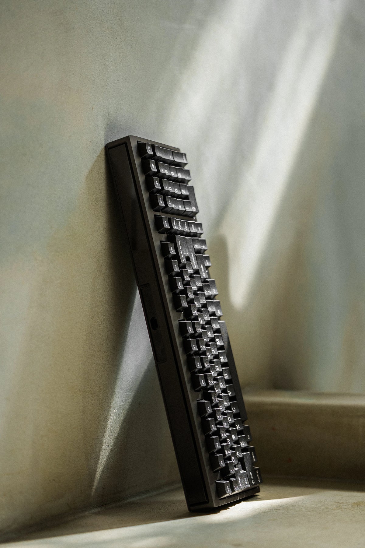 Mode Prologue in Black Sesame leaning against a sunlit wall